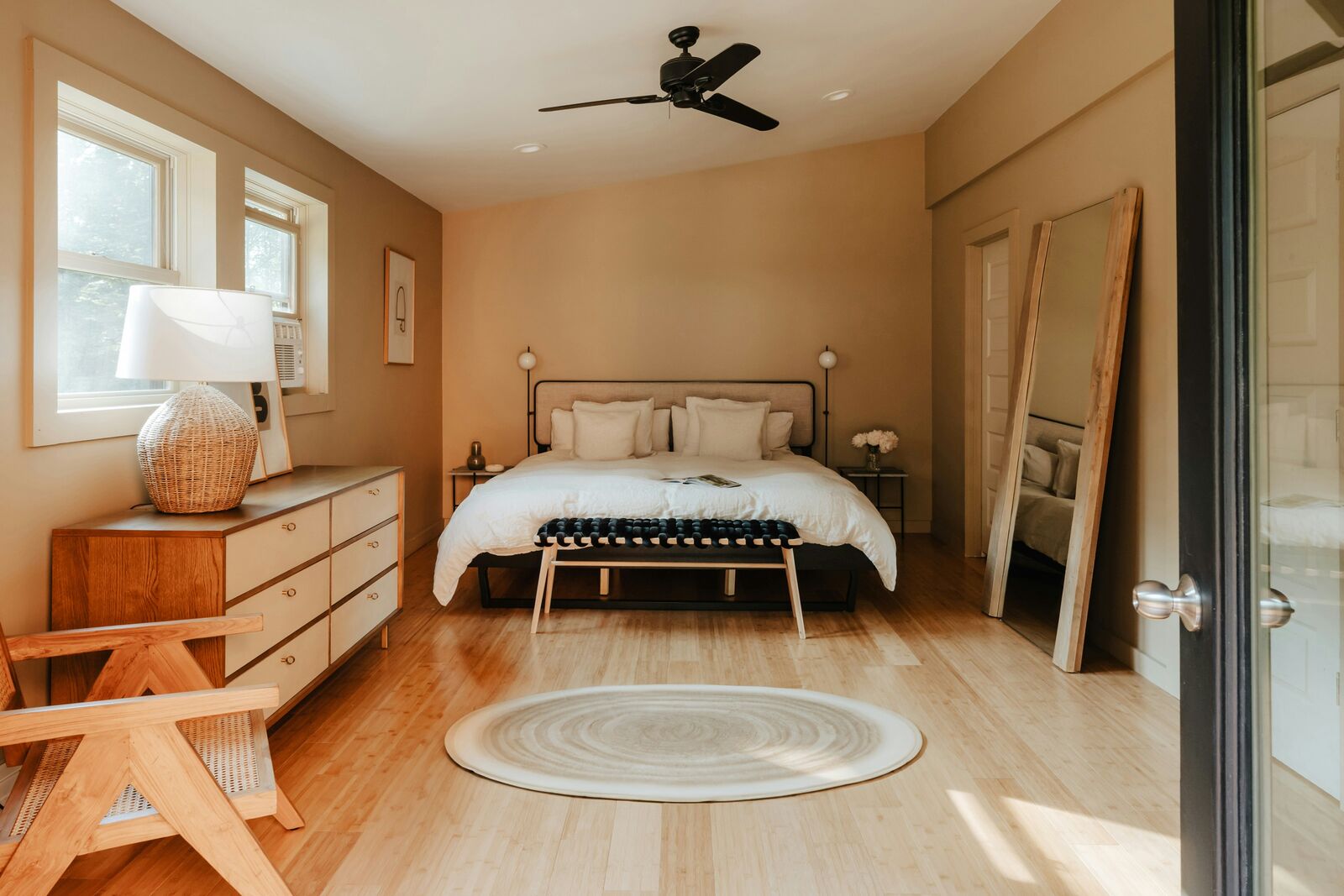 A freshly made bed in a bright, warm bedroom